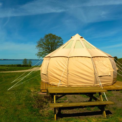 a yurt sitting on a picnic table in a field at Fyn Glamping in Nyborg