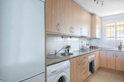 a kitchen with a sink and a washing machine at Carvajal Luxury Apartments - Free Parking in Fuengirola