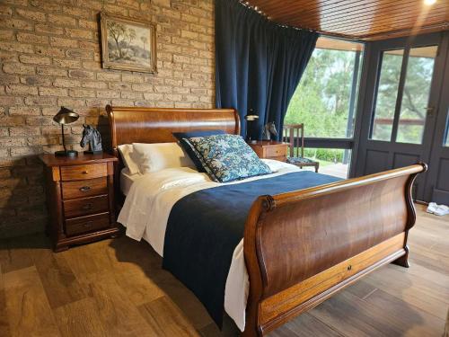 a bedroom with a bed with a blue comforter at Hill Top Park - Apple Tree Studio in Kilmore