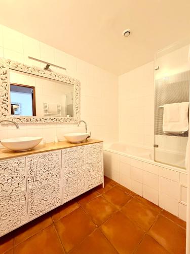 a bathroom with two sinks and a tub and a mirror at Domaine Des Médards in Beaulieu-sur-Loire