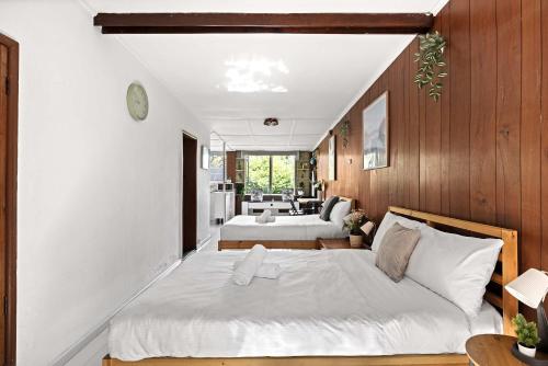 a bedroom with two beds and a living room at Simple 2-Double Bed Studio Stay at Peakhurst in Peakhurst