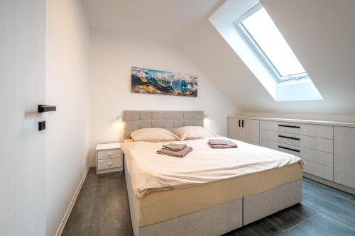 a bedroom with a bed and a skylight at Apartmány Vulcano in Perná