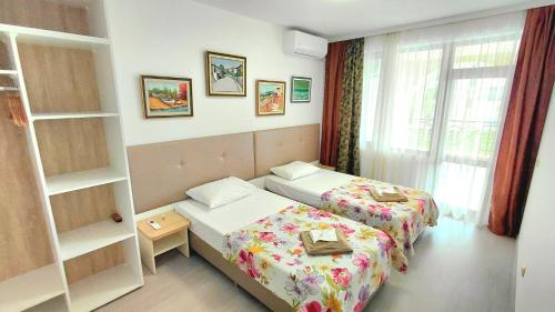 a hotel room with two beds and a window at Luxury Lighthouse Golf Apartment in Balchik