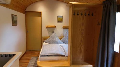 a small bed in a room with a window at Pfälzer Zirkuswagen in Ranschbach