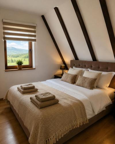 a bedroom with a large bed with two towels on it at Iskrin breg in Ribnica