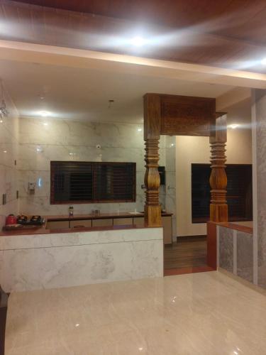 a kitchen with a counter and columns in a room at Sri Skandaa in Sringeri