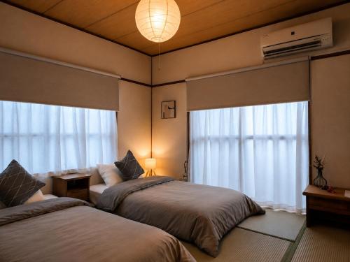 a bedroom with two beds and a large window at DiDi Sakura 205 in Tokushima