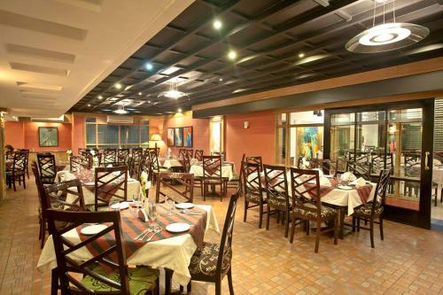 a restaurant with tables and chairs in a room at Well Park Residence in Chittagong