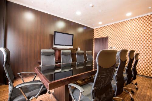a conference room with chairs and a table and a television at Prezident Hotel in Novi Sad