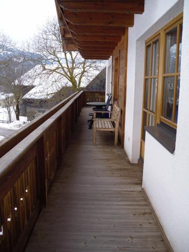 a wooden porch with a bench on the side of a building at Nagelehof in Ainet