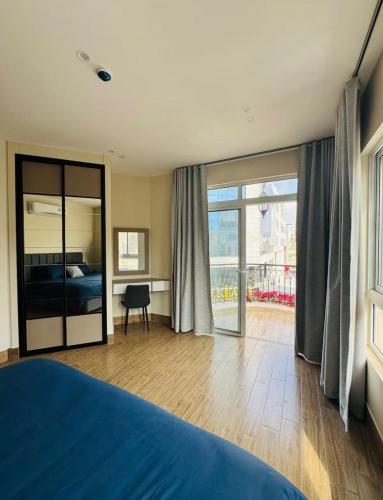 a bedroom with a bed and a view of a balcony at 7th Circle Suite in Umm Uthainah