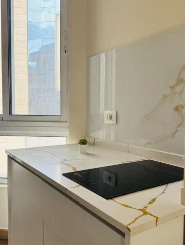 a kitchen with a marble counter top and a window at 7th Circle Suite in Umm Uthainah