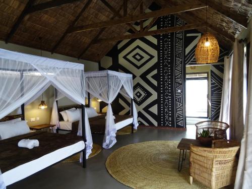 a bedroom with two beds with mosquito nets at Honey Badger Lodge in Moshi