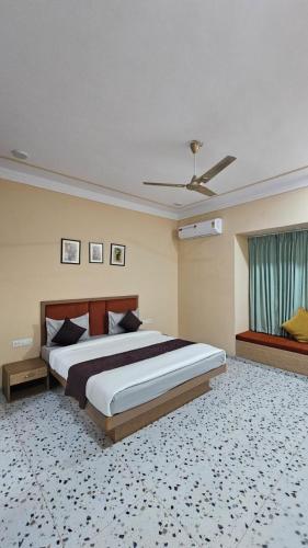 a bedroom with a large bed and a ceiling fan at Raghuvan Farm in Jaipur