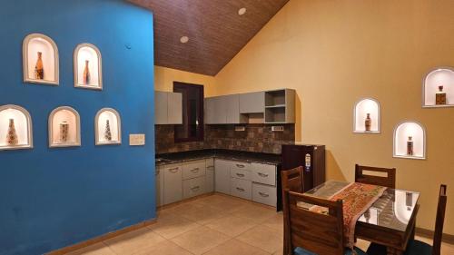 a kitchen with a table and a blue wall at Raghuvan Farm in Jaipur