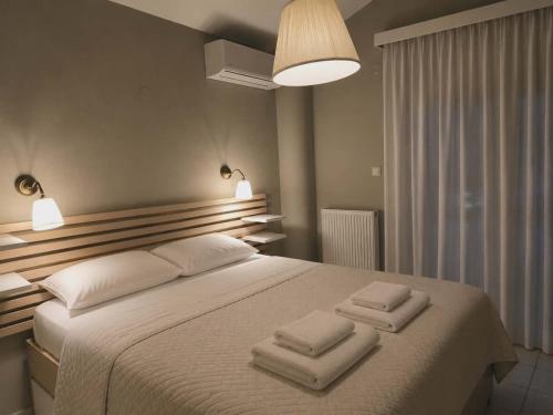a bedroom with a large bed with two towels on it at Eva Maisonette in Iraklitsa