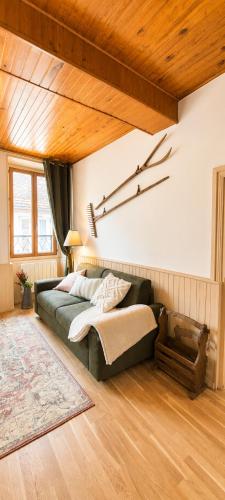 a bedroom with a bed and a couch in a room at Le Refuge de Mandrin, Elegance et tranquilité in Saint-Genix-sur-Guiers