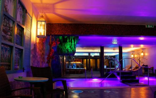 Lavendel Spa Hotel في تالين: غرفة بها أضواء أرجوانية في مطعم