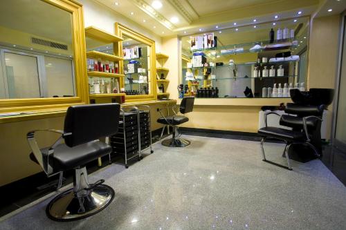 a hair salon with three chairs and a barber shop at Prezident Hotel in Novi Sad