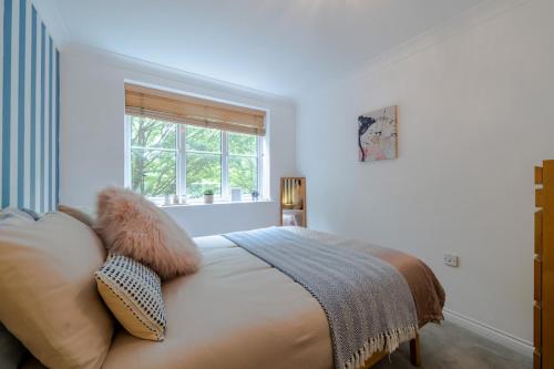 a bedroom with a bed with pillows and a window at Ascot Racecourse Apartment in Ascot