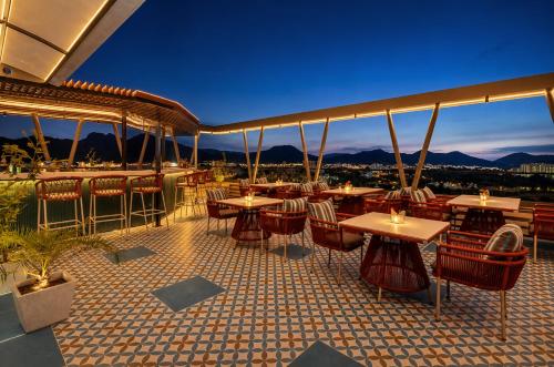 a restaurant with tables and chairs on a roof at Paradise Bliss Udaipur - Luxury Boutique Hotel in Udaipur