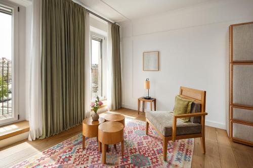 ein Wohnzimmer mit einem Stuhl und einem Tisch in der Unterkunft Louis Hotel in München