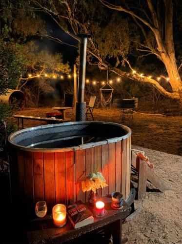 a hot tub with candles and lights in a yard at Hollow Mountain Getaway 2 by Tiny Away in Laharum