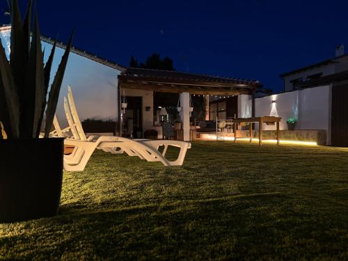 a white bench sitting in a yard at night at La Casita del Tejar in Cardiel de los Montes