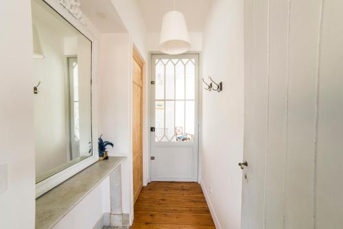 un couloir avec un miroir et une fenêtre dans l'établissement Bed and Breakfast La Cordonnerie, à Villandraut