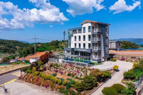 an apartment building with a garden in front of it at Yeosu Little Forest Pension in Yeosu