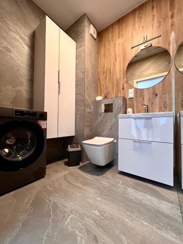 a bathroom with a washing machine and a washer at Apartament Tosia in Chełm