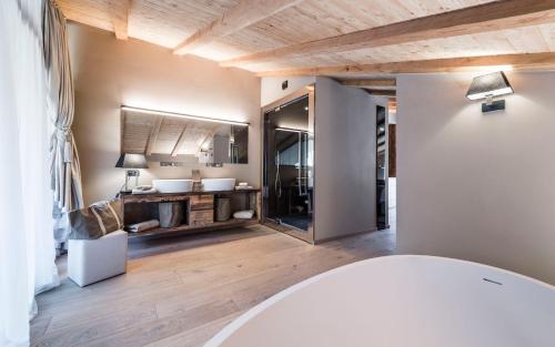 y baño con lavabo y espejo. en Hotel Montchalet en Ortisei