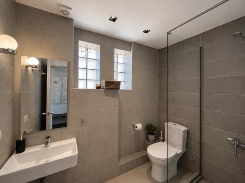 a bathroom with a toilet and a sink and a shower at Aelia Living in Stavros