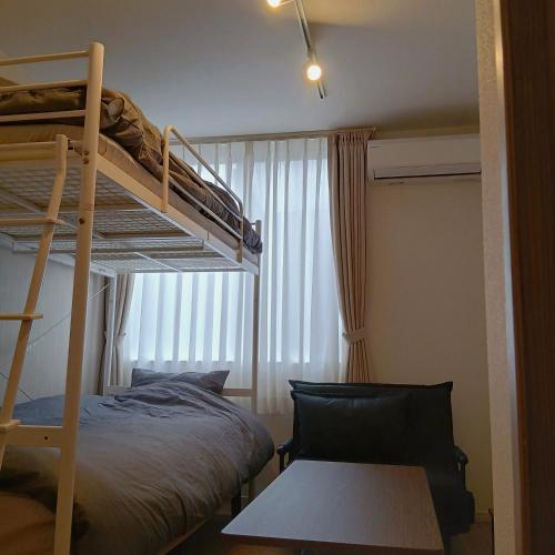a bedroom with a bunk bed and a chair at Hotel Route35 Shiomi in Sasebo