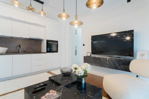 a living room with a table and a tv at Liberty Central Apartment in Tuzla