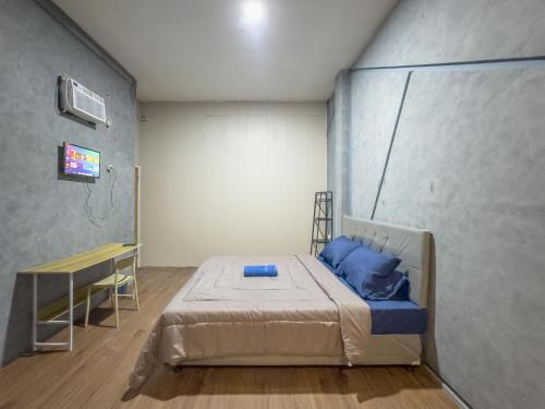 a room with a bed and a table in it at Kamar Pluit Karang in Jakarta