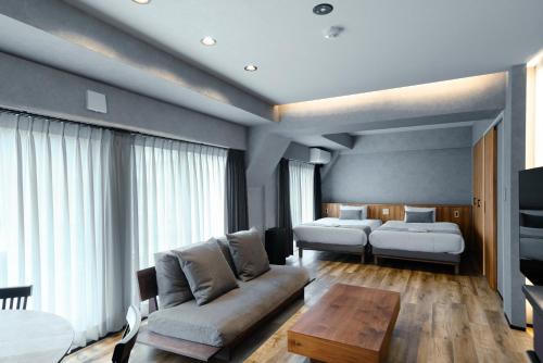 a living room with a couch and two beds at ulu Tokyo in Tokyo