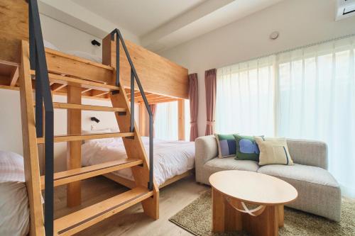 a small bedroom with a bunk bed and a couch at Cavatina in Sapporo