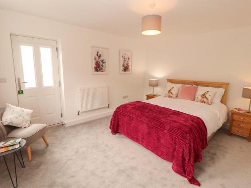 a bedroom with a large bed with a red blanket at Little Plumtree in Milnthorpe