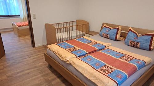 a bed with blue and orange pillows in a bedroom at Haus Linde in Wengenroth