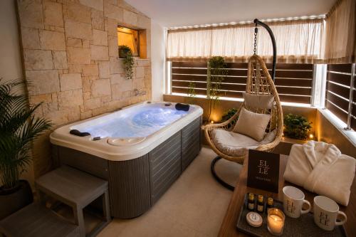 a large bathroom with a tub and a swing at ELLE Rooms & Suites in Paralia Katerinis