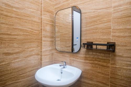 a bathroom with a sink and a mirror on a wall at Urbanview TWH Costel near Stadion Maguwoharjo Yogyakarta in Yogyakarta
