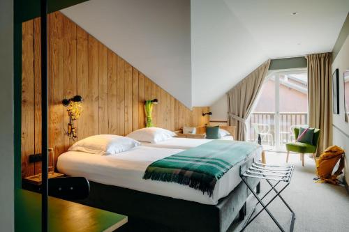 a bedroom with a large bed and a large window at PlanB Hotel - Living Chamonix in Chamonix