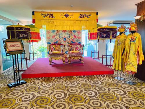a bed in a room with two men standing next to it at Century Riverside Hotel Hue in Hue