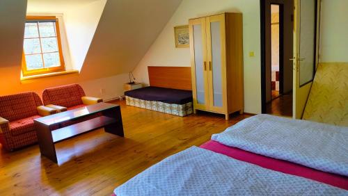 a bedroom with a bed and a table and a couch at Andels apartments Vila 3 in Rynholec