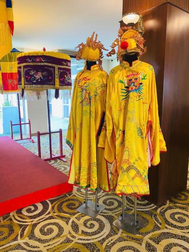 two mannequins dressed in yellow robes in a room at Century Riverside Hotel Hue in Hue