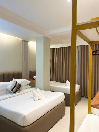 two beds in a hotel room at Olive's Suites in Kalibo