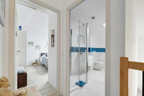a bathroom with a glass shower and a bedroom at Chambre D'hôtes - Chambre Marine in La Plaine-sur-Mer