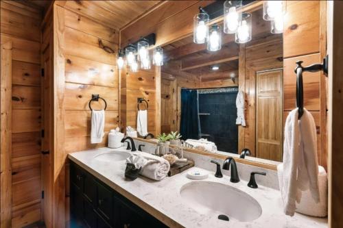a bathroom with two sinks and a large mirror at Awesome Adventures By Avada Properties in Sevierville