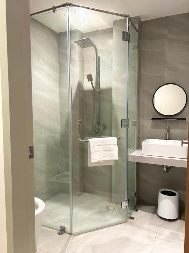 a glass shower in a bathroom with a sink at Olive's Suites in Kalibo